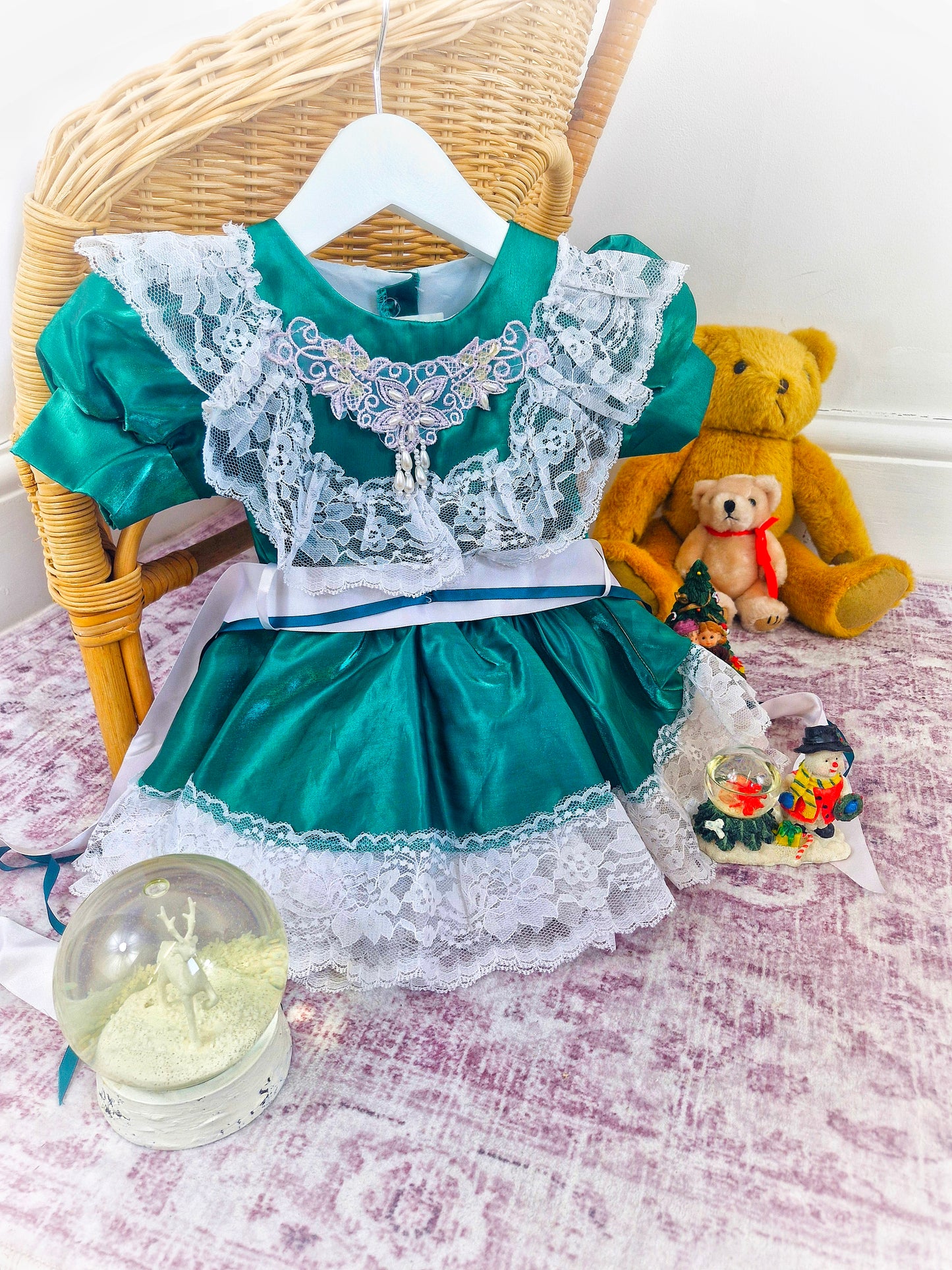12-18 months. Green satin dress with white lace and ribbon