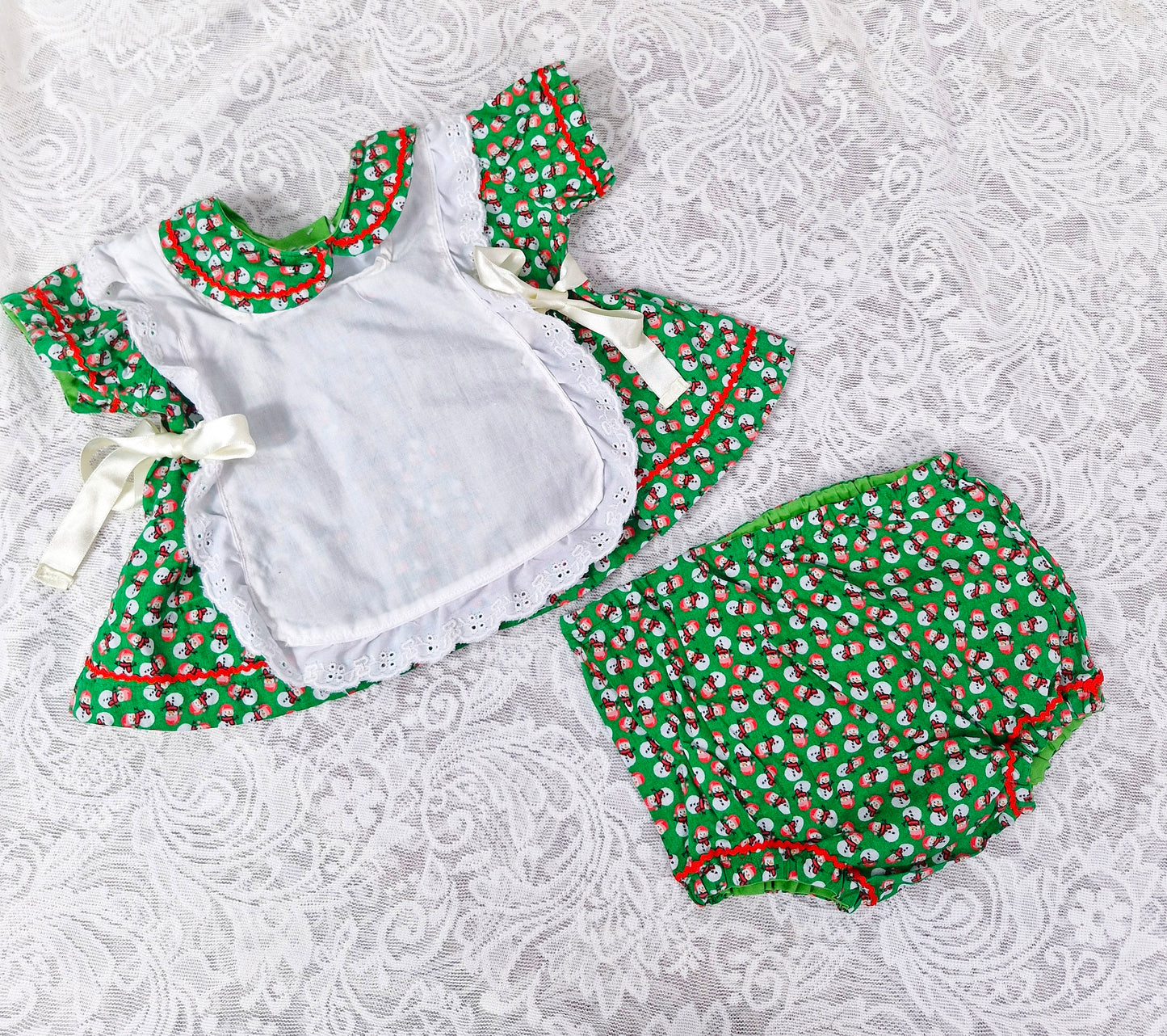0-3 months. 3 piece set; dress, bloomers and pinny. Green with snowman print. Handmade.