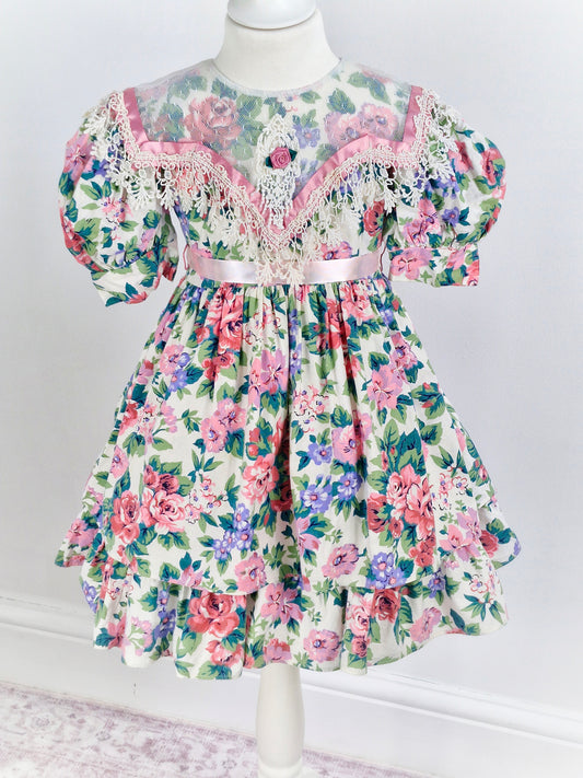 4-5 years. Vintage Jinelle, pastel floral print. Sheer bib, pink ribbon and rosette