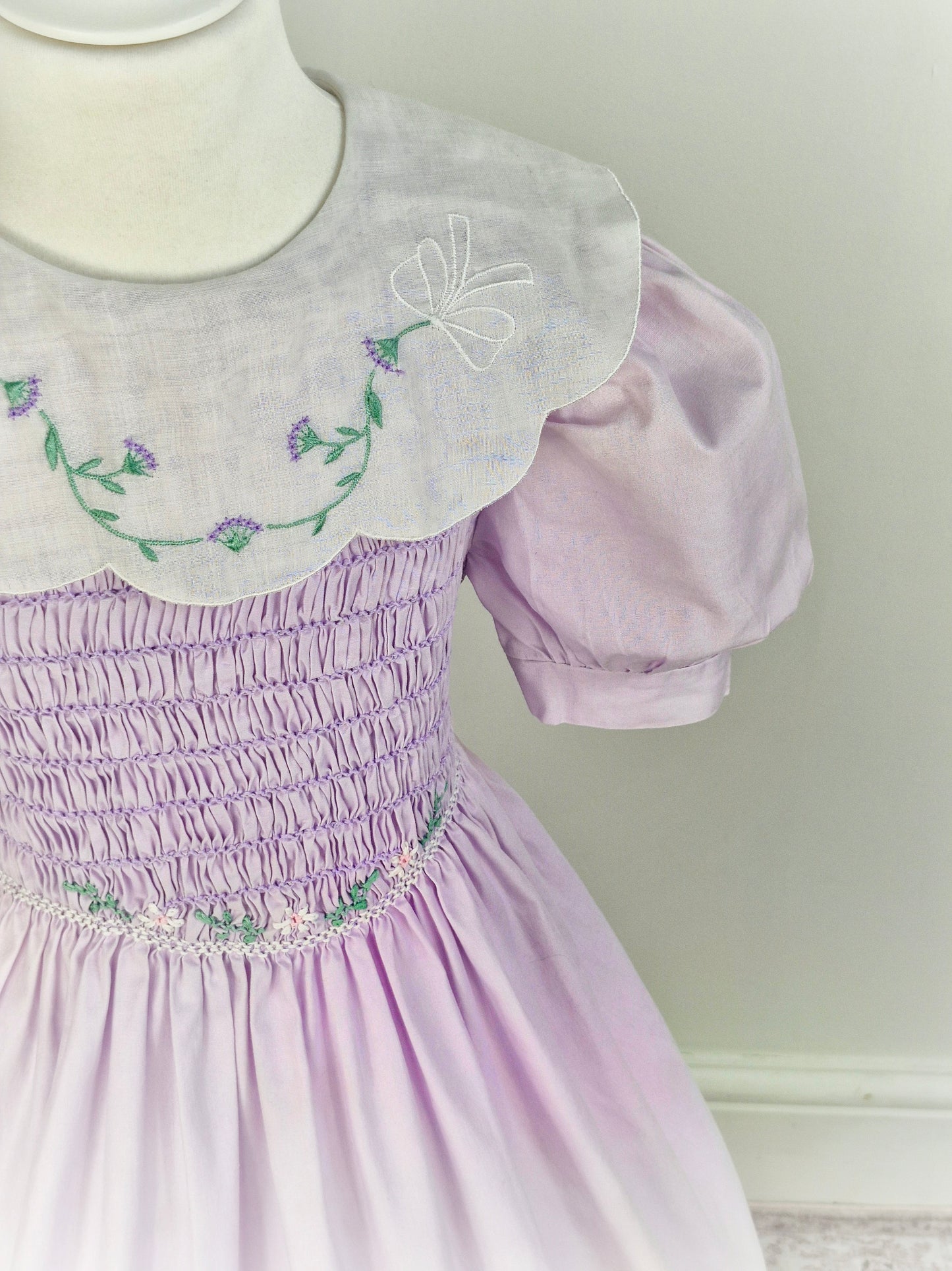 5-6 years. Polly Flinders, vintage lilac smock dress with white bib embroidered with delicate flowers and puff sleeves
