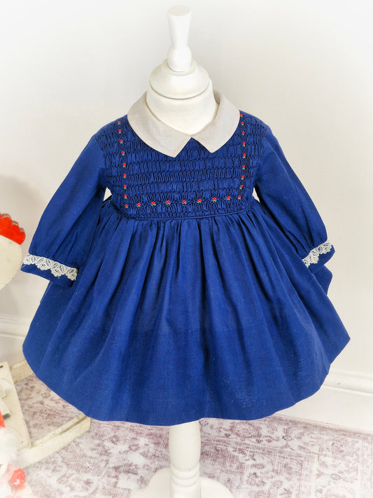 2 years. Navy vintage Polly Flinders smock dress with white collar and red embroidered flowers