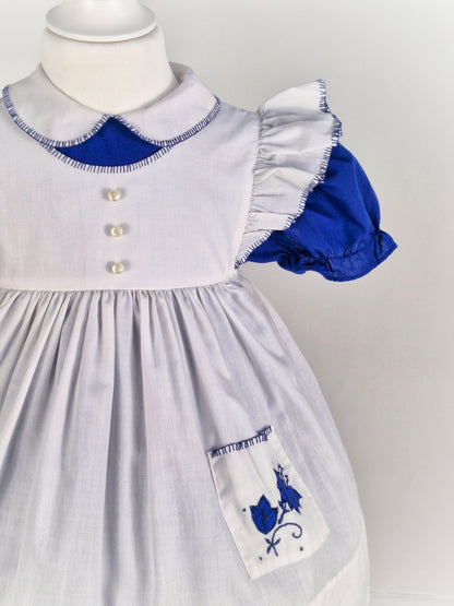 2-3 years. Vintage two-piece, navy dress with white collar and puff sleeves, with white flutter shoulder apron and embroidered pockets