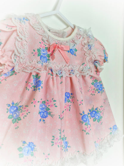 3-6 months. Light pink vintage dress with blue floral print and white lace details