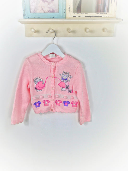 2 years. Pink vintage cardigan with playful, knitting cats
