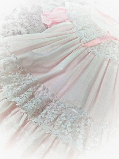 18 months - 2 years. Pink vintage dress with puff sleeves and white apron from Kotton Kandi with lace layers and pink ribbon