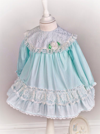 2 years. Mint vintage Alexis with white lace and frills. Lacey bib with dainty flower and long sleeves