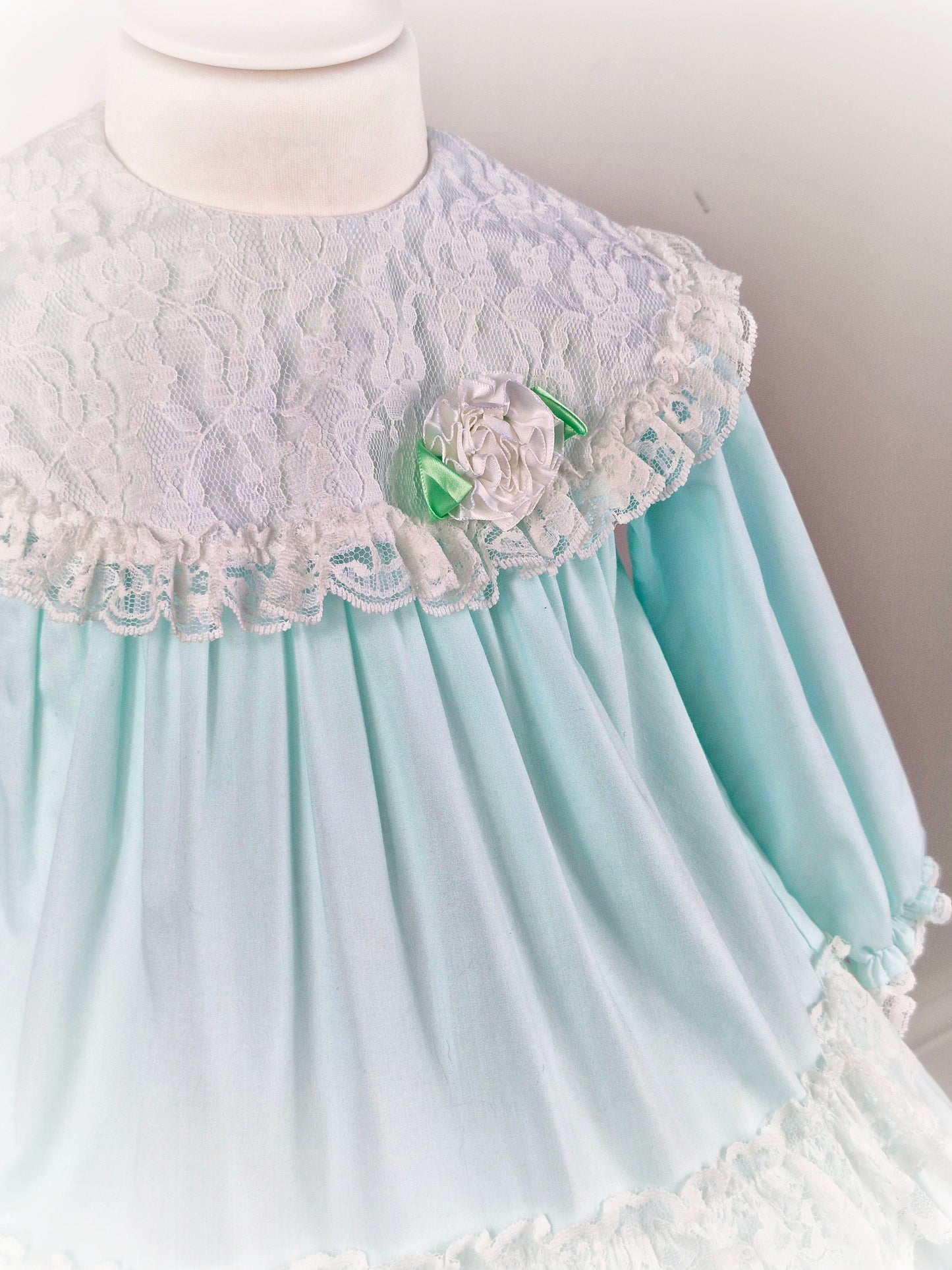 2 years. Mint vintage Alexis with white lace and frills. Lacey bib with dainty flower and long sleeves