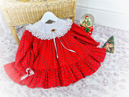 9-12 months. Red vintage Bryan with festive floral print, white Cuddle bib and red rosette