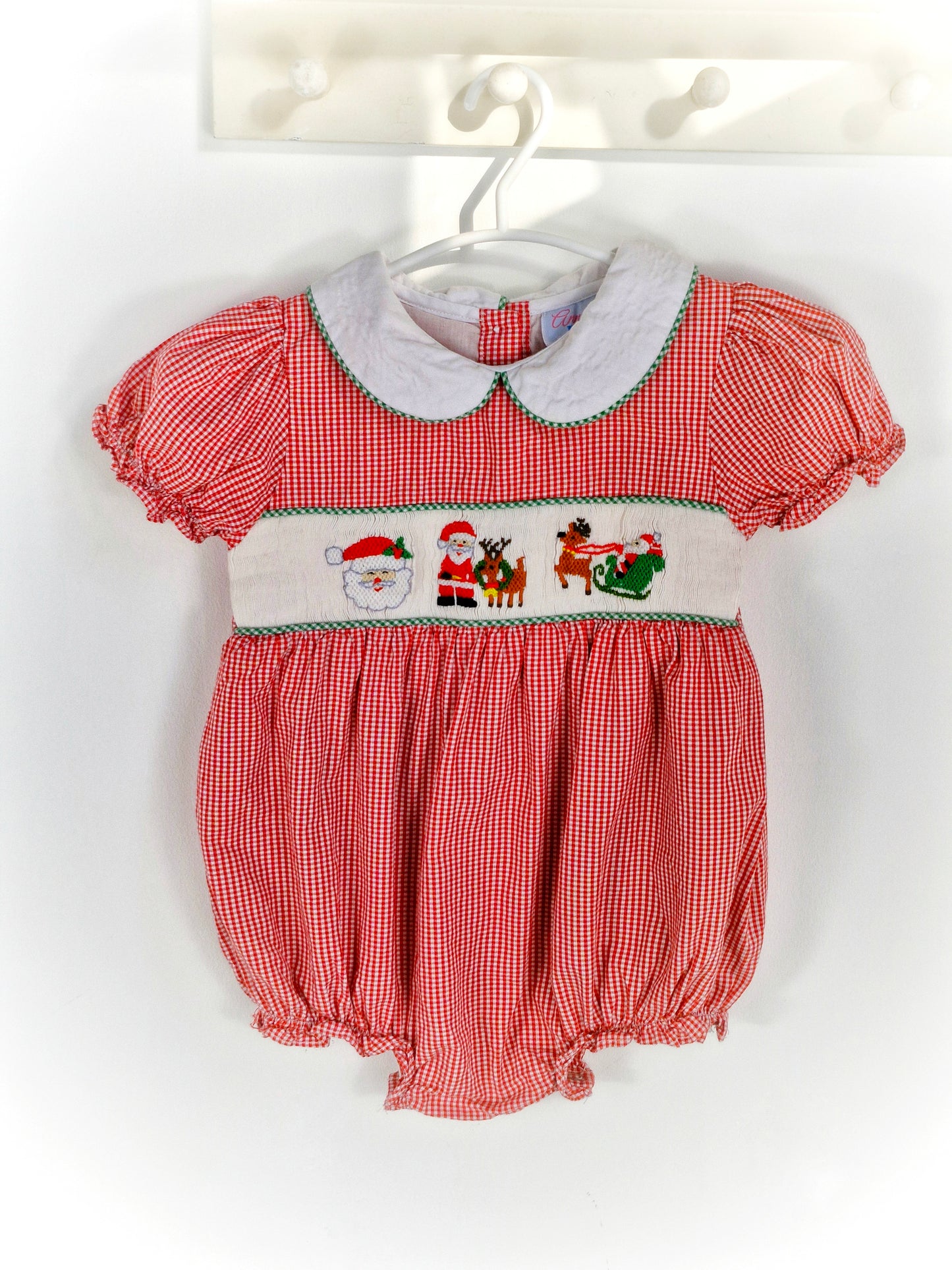 12-18 months. Red and white gingham smocked romper with embroidered santas, white Peter Pan collar and puff sleeves