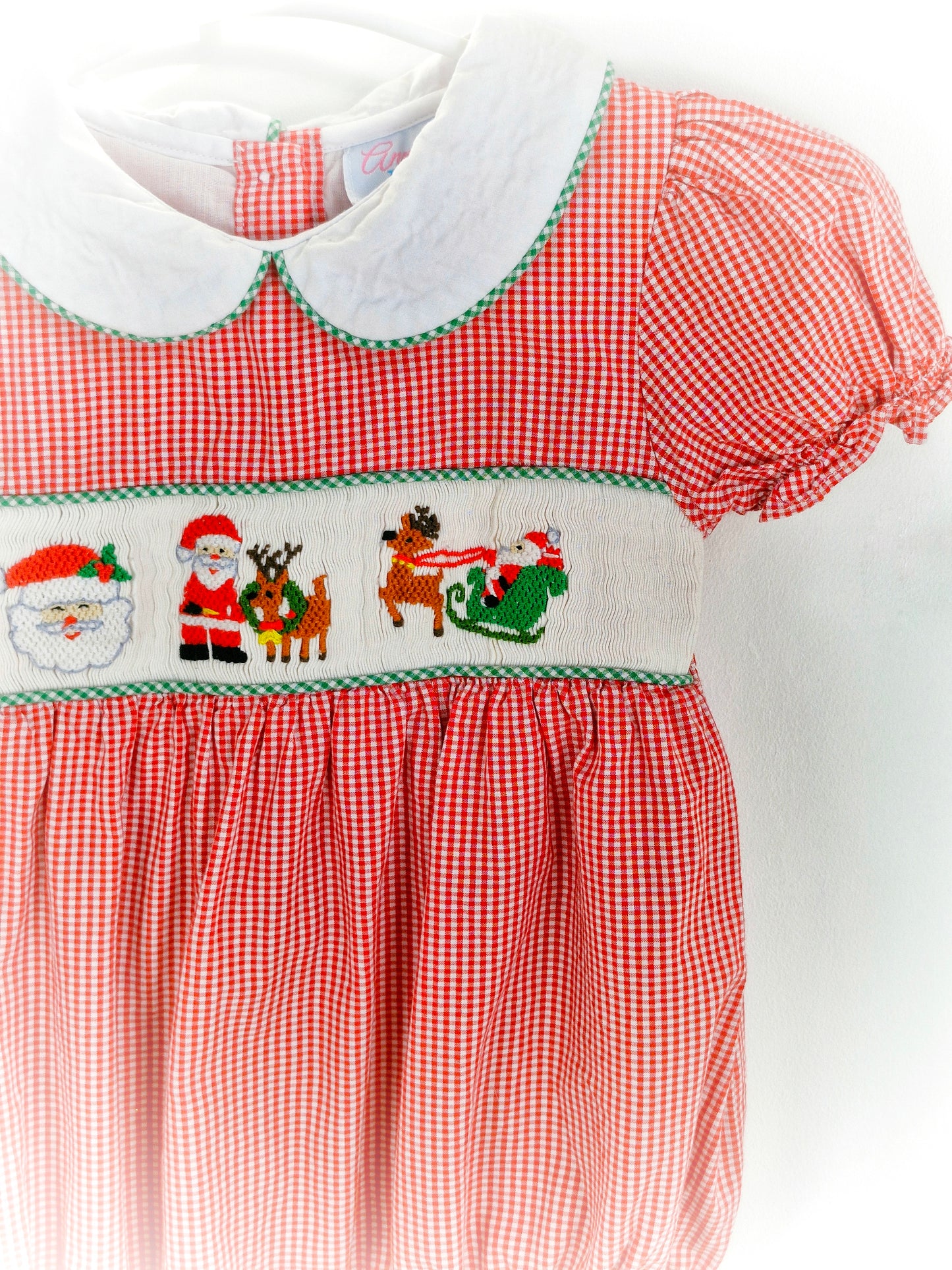 12-18 months. Red and white gingham smocked romper with embroidered santas, white Peter Pan collar and puff sleeves