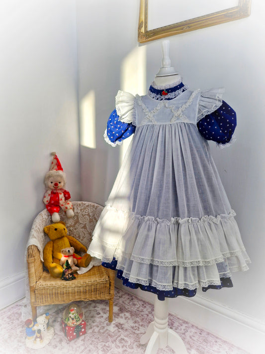 6 years. Navy floral vintage Bryan with white flutter sleeve, ruffled layered apron