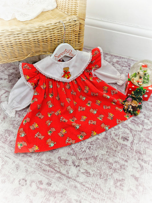 9-12 months. Red polka dot vintage dress from Nannette with white sleeves and bib, christmas teddy print and and flutter shoulders