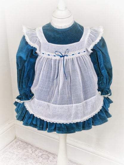 2 years. Vintage teal velvet dress with white apron, frill shoulders and ribbon details