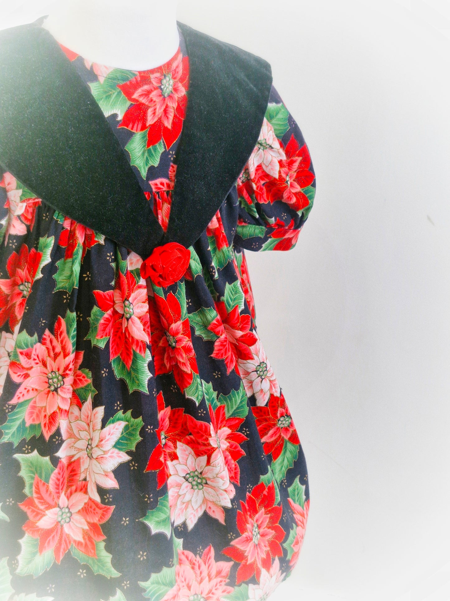 3 years. Black vintage dress by L.J Girls with red and pink poinsettia print and green leaves.