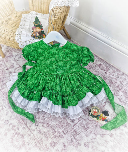 12-18 months. Green floral Lid'l Dolly with white lace ruffles