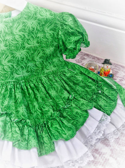 12-18 months. Green floral Lid'l Dolly with white lace ruffles