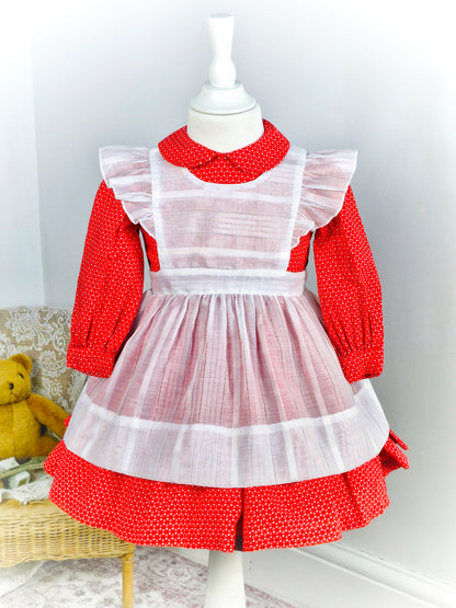 2-3 years. Handmade two-piece, red long sleeve dress with Peter Pan collar and white heart print. White apron with flutter shoulders and tie back.