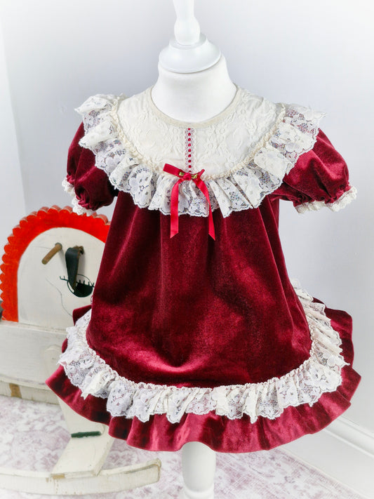3 years. Vintage burgundy soft velvet dress with white lace bib and trim, red ribbon and rosette