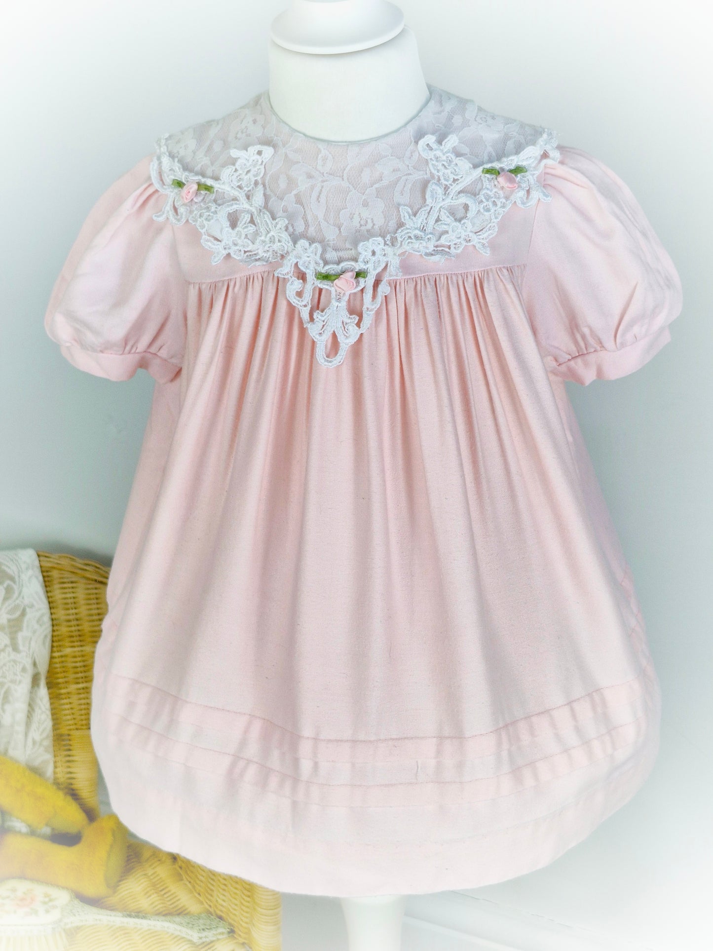 2 years. Light pink vintage dress with elegant lace bib and rosettes