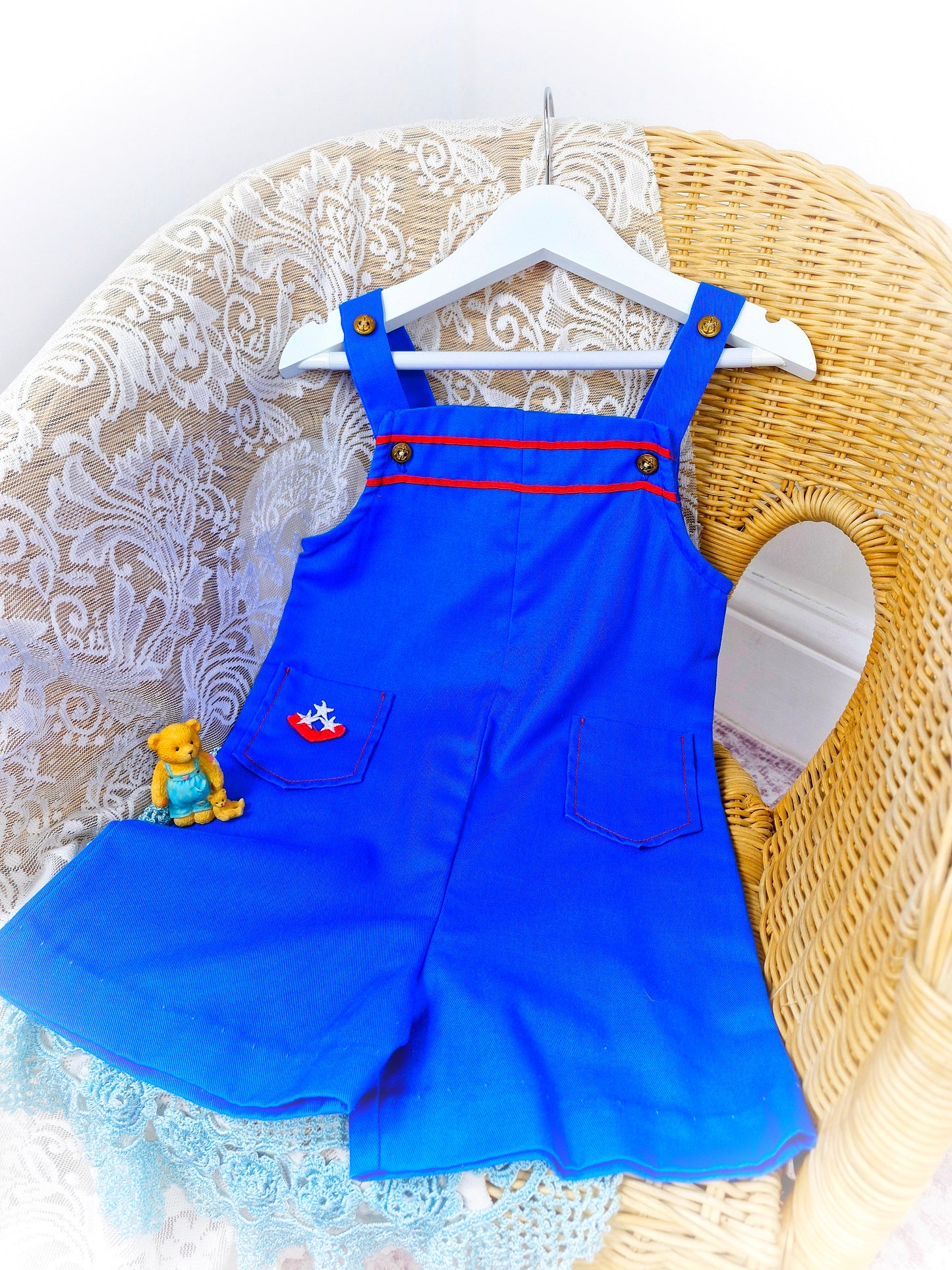 2-3 years. Royal blue short dungarees with red details, gold nautical buttons and pockets
