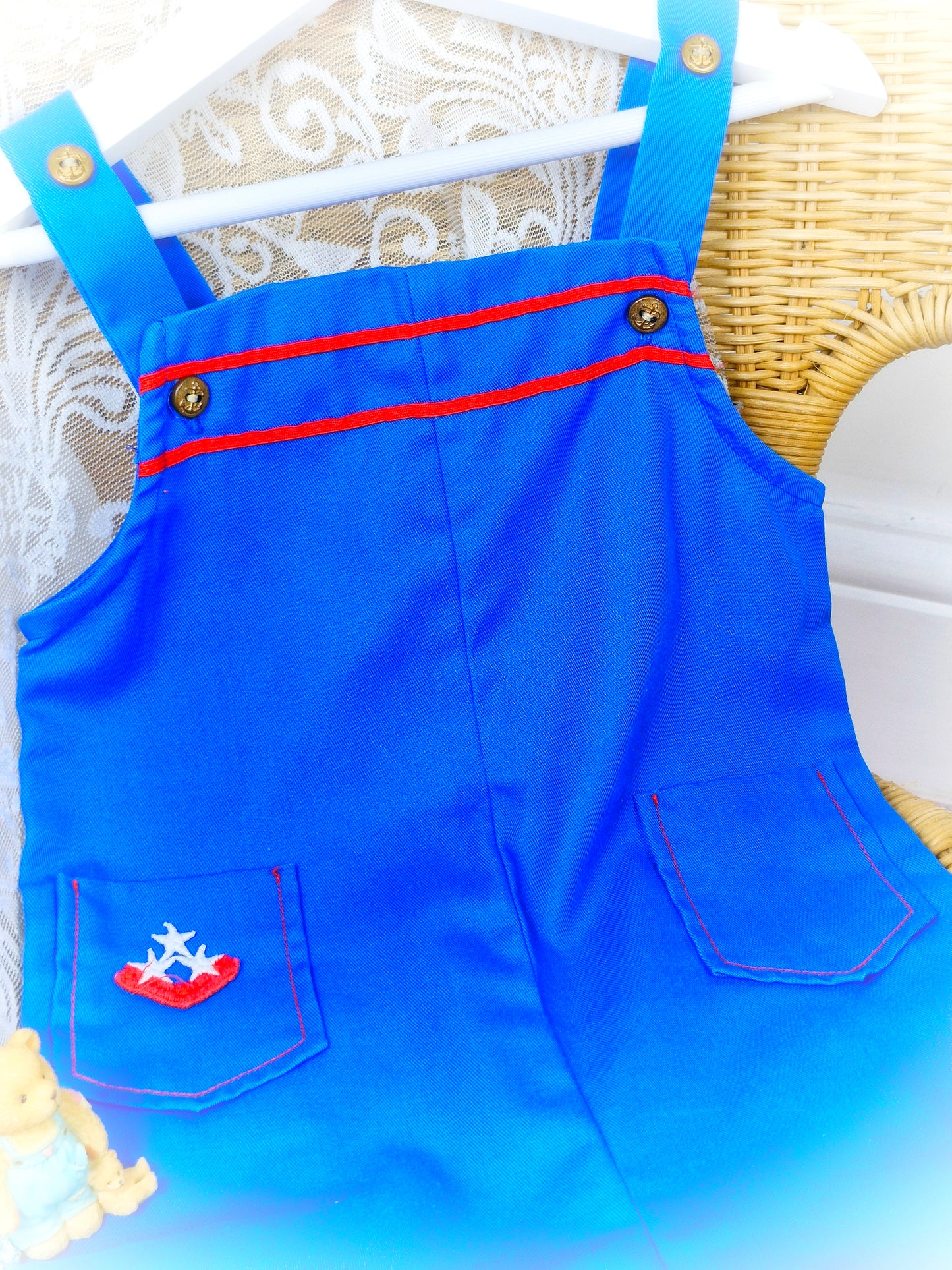 2-3 years. Royal blue short dungarees with red details, gold nautical buttons and pockets