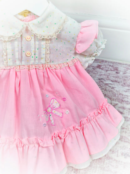 6-9 months. Pink and white vintage dress with flowers, lace and an embroidered bow