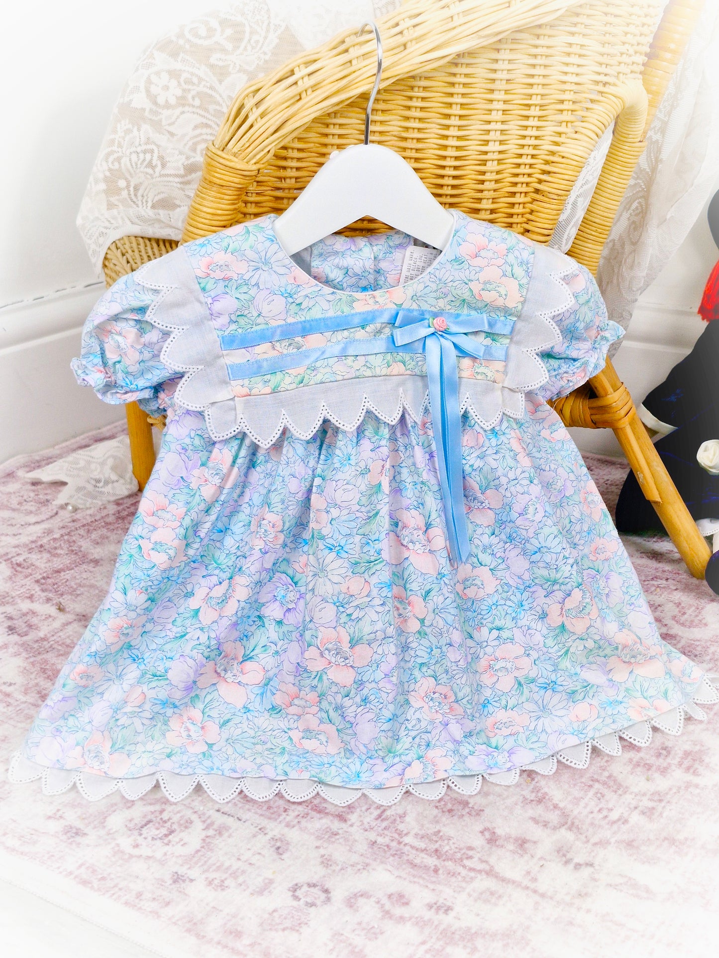 9-12 months. Vintage Good Lad of Philadelphia, light blue floral dress with white trim, blue satin ribbon and a pink rosette