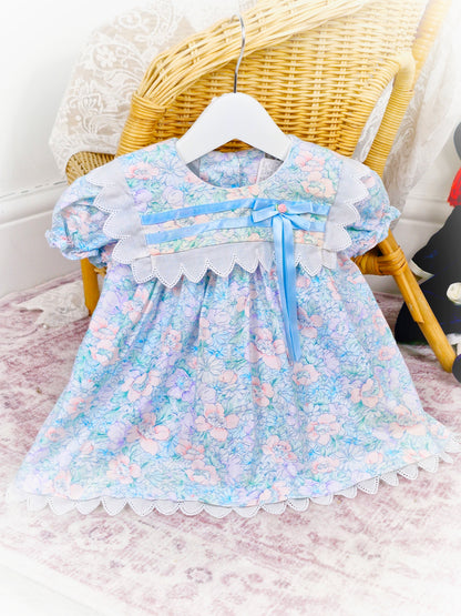 9-12 months. Vintage Good Lad of Philadelphia, light blue floral dress with white trim, blue satin ribbon and a pink rosette