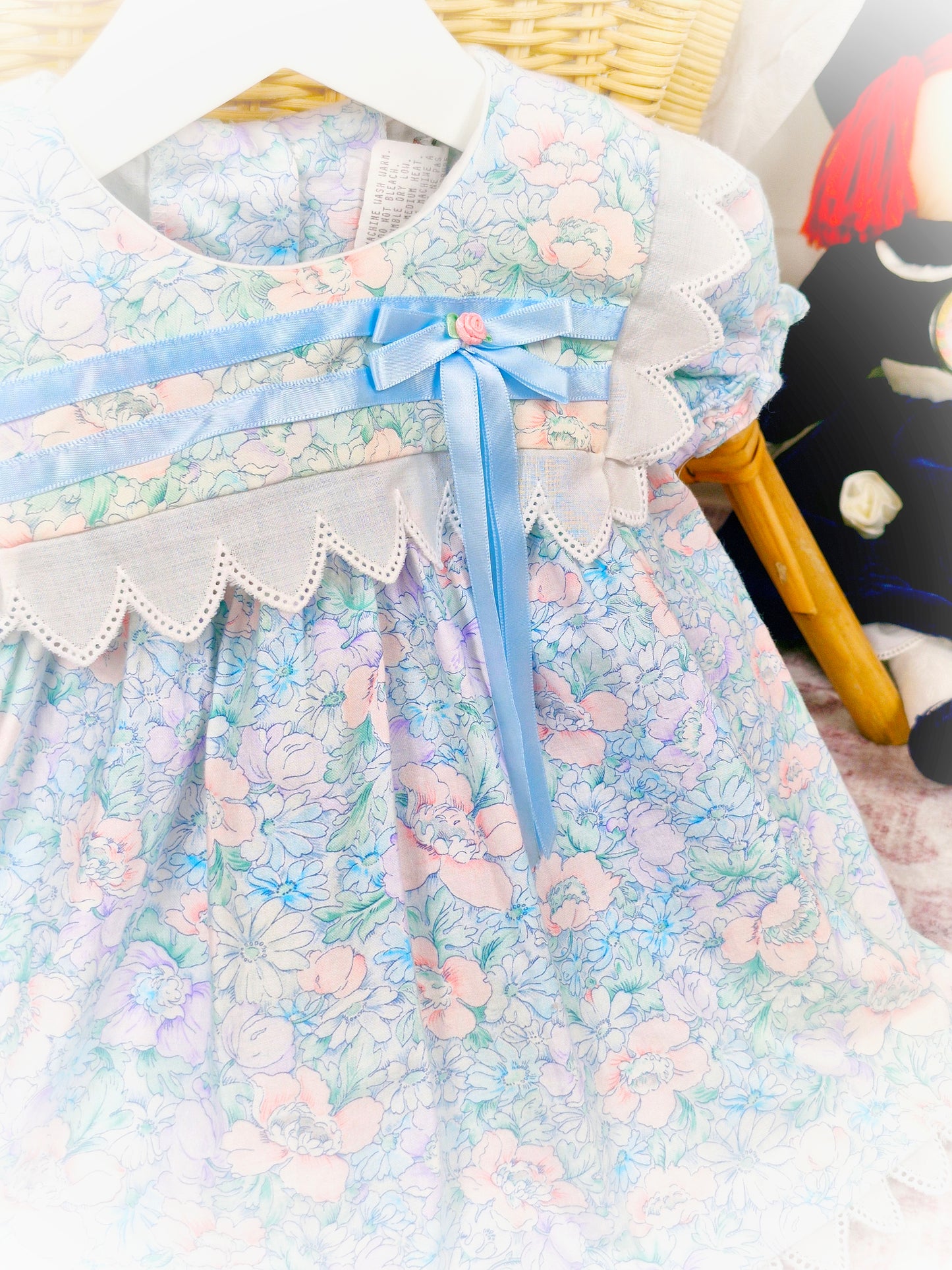 9-12 months. Vintage Good Lad of Philadelphia, light blue floral dress with white trim, blue satin ribbon and a pink rosette