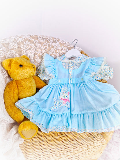 12 months. Light blue vintage dress with flutter shoulders, puff sleeves and collar. Little lamb applique.