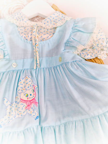 12 months. Light blue vintage dress with flutter shoulders, puff sleeves and collar. Little lamb applique.