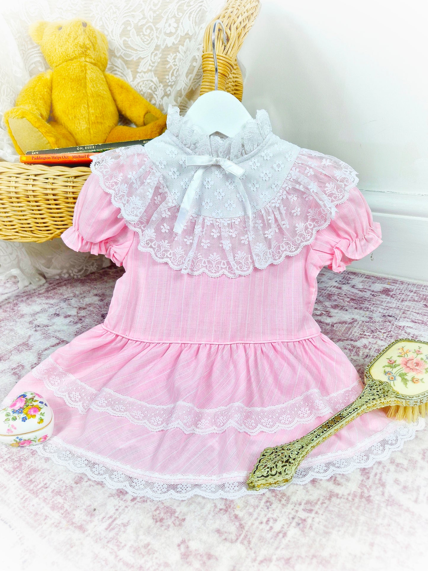 12-18 months. Pink vintage drop waist dress with high neck, white lace details and frilly bib