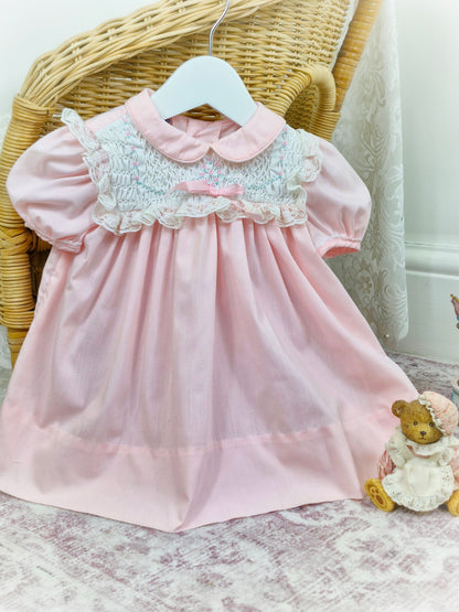 12 months. Pink and white vintage Polly Flinders dress with pink and blue smocking and lace details