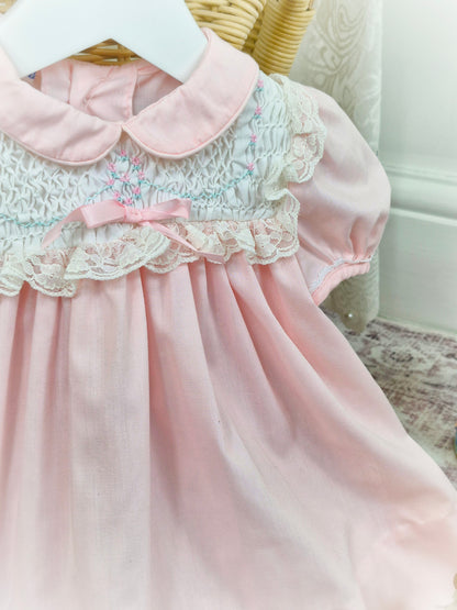 12 months. Pink and white vintage Polly Flinders dress with pink and blue smocking and lace details