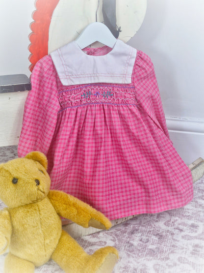 18-24 months. Pink checkered vintage smock dress with long sleeves and white bib