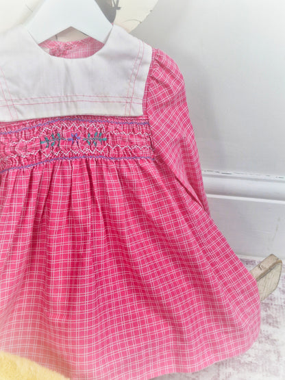 18-24 months. Pink checkered vintage smock dress with long sleeves and white bib