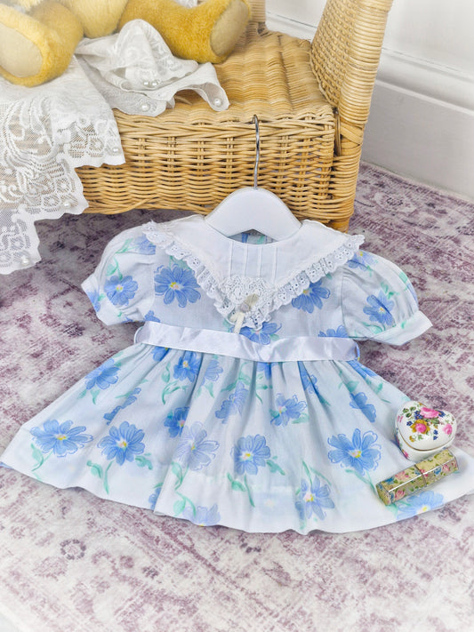 6-9 months. White vintage dress with blue floral patterns, white bib and satin ribbon