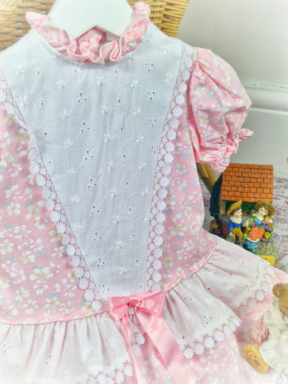 12-18 months. Pink and white vintage floral drop waist dress with frill neck and pink satin ribbon