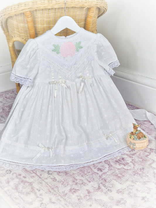 3-4 years. White vintage broderie anglais dress with lace, ribbon and a pink flower applique