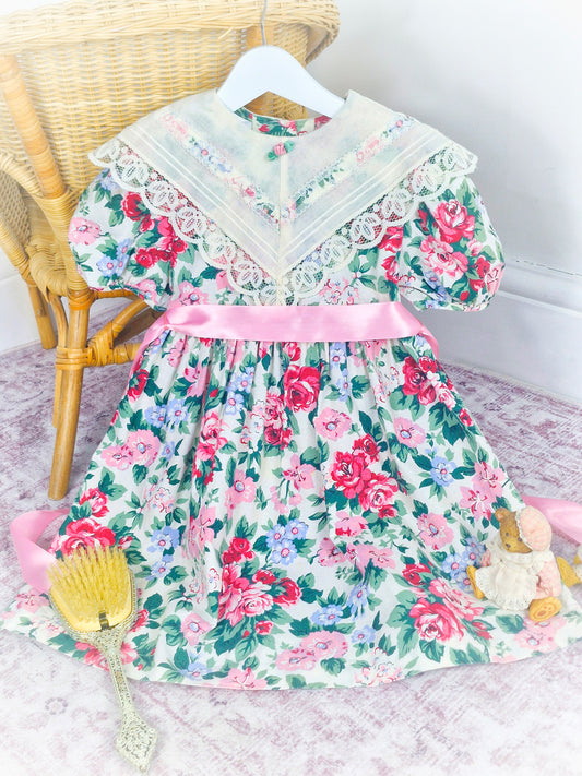5 years. Floral Bonnie Jean with cream lace bib and pink satin ribbon