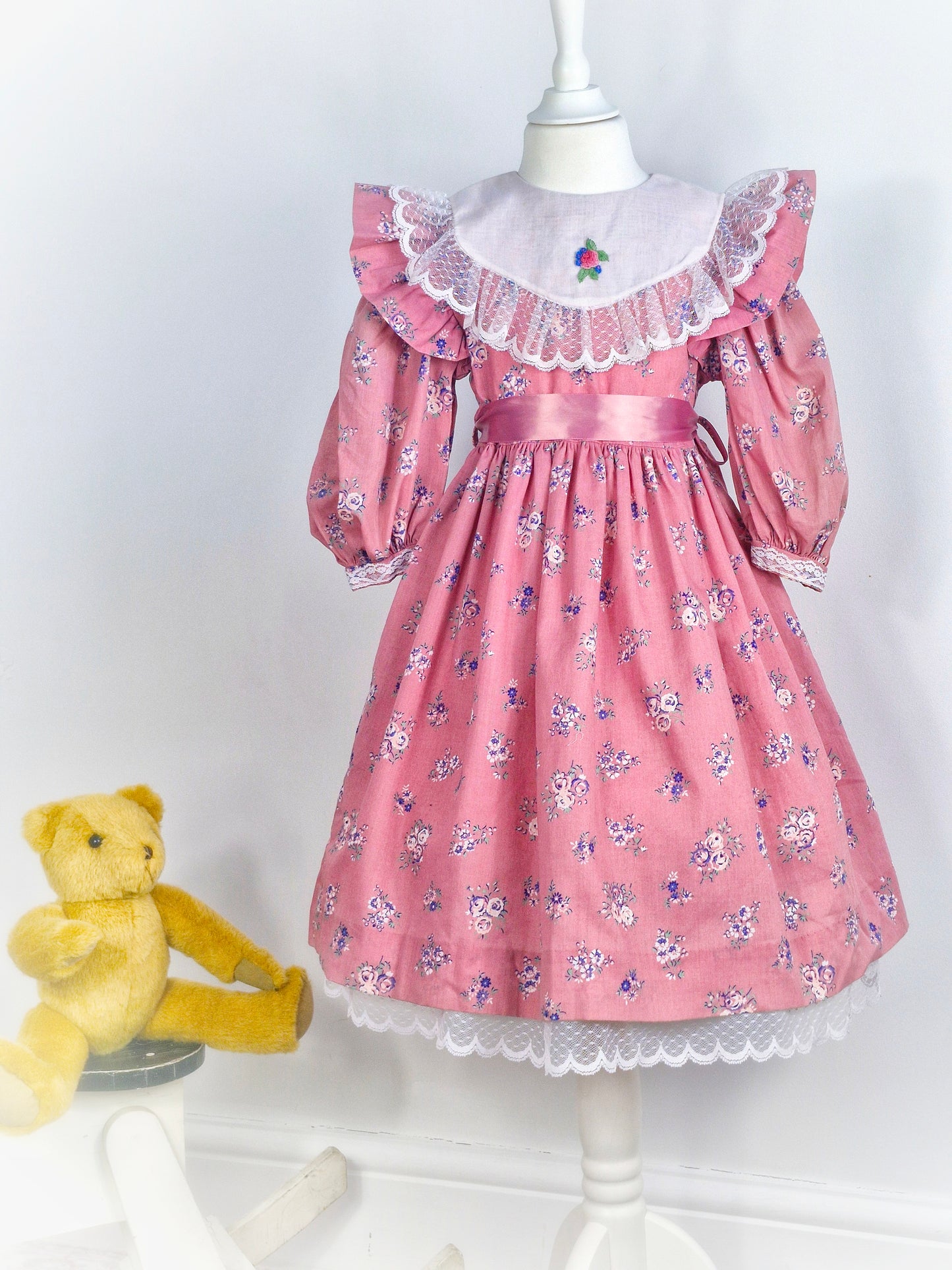 6-7 years. Pink floral patterned vintage dress with white lace details on the collar and hem