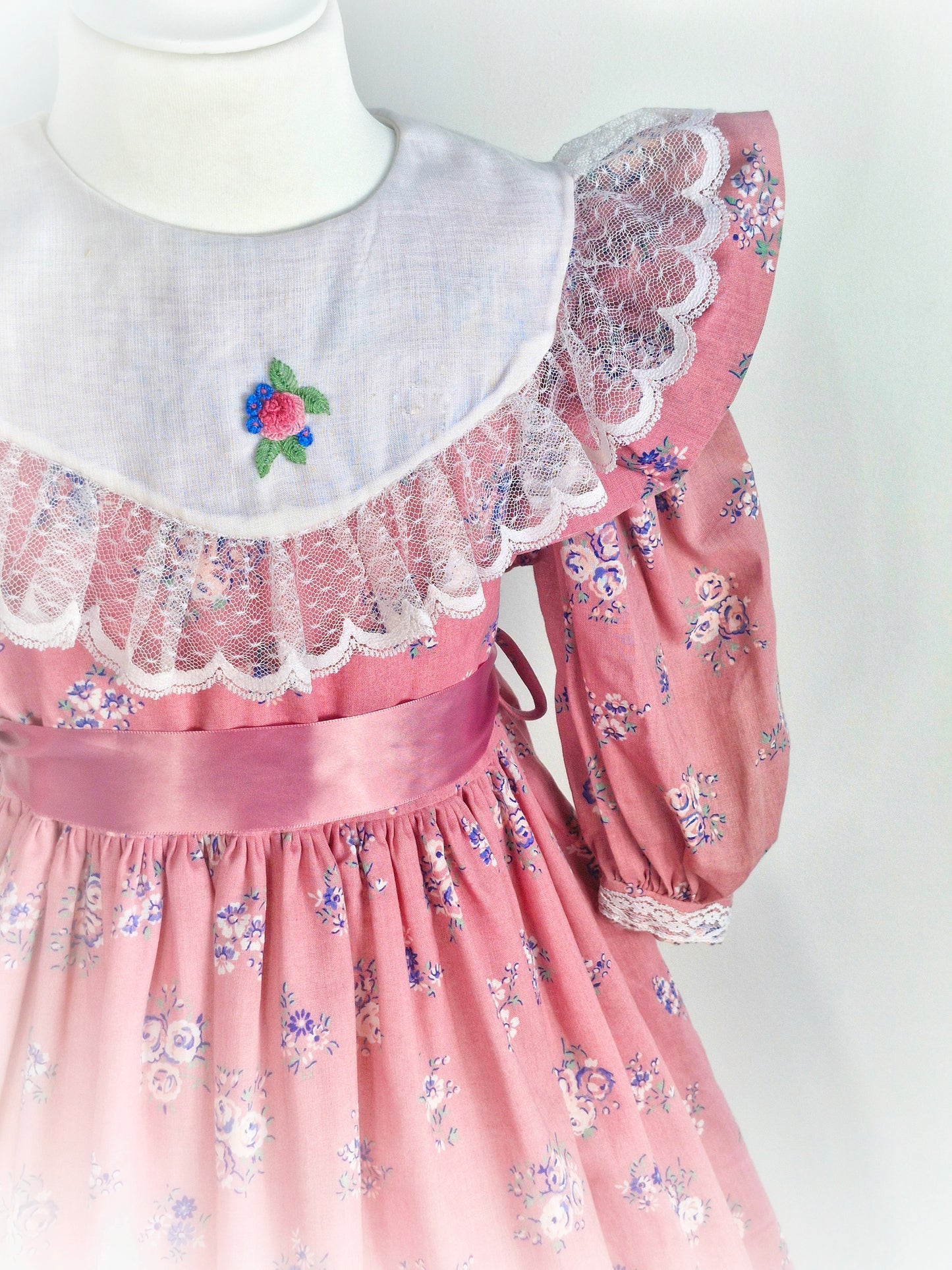 6-7 years. Pink floral patterned vintage dress with white lace details on the collar and hem