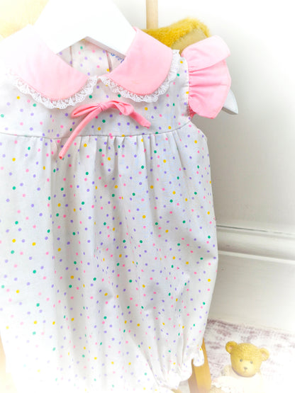 9-12 months. White vintage romper with pink collar, flutter shoulders and rainbow polka dots