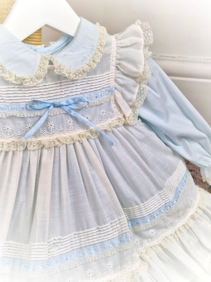 12-18 months. Light blue vintage dress from Toddle Tyke with white apron, satin ribbon, lace and frills