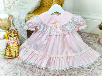 9 months. Pink vintage Bryan with white lace details, puff sleeves and satin bow