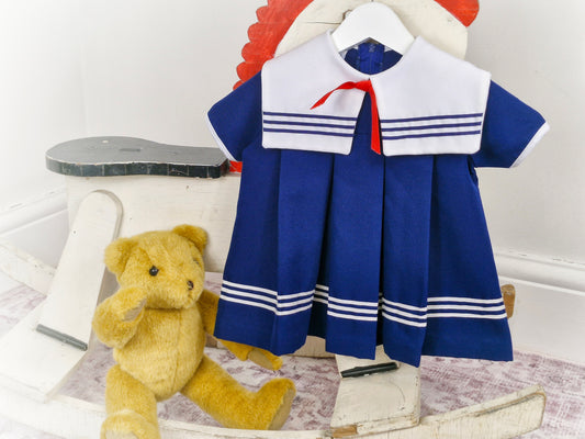 12-18 months. Navy vintage sailor dress with white bib and red ribbon