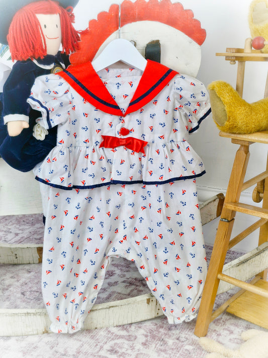 9-12 months. White nautical romper with red bib and bow and navy trim