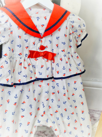 9-12 months. White nautical romper with red bib and bow and navy trim
