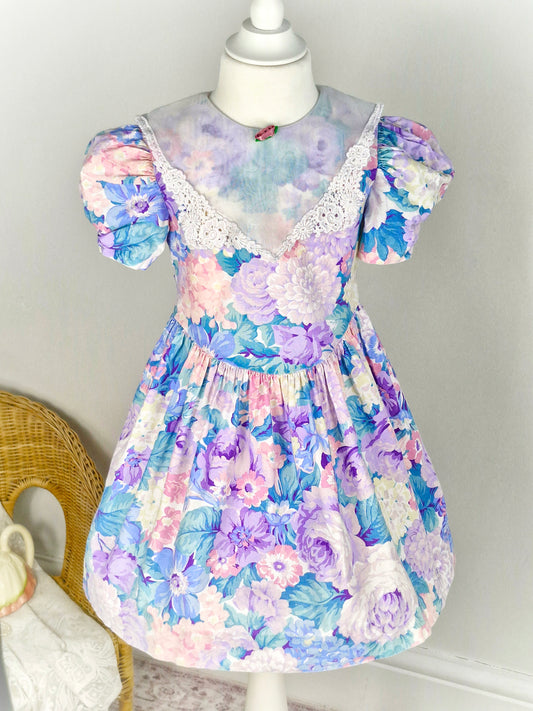 4 years. Lilac floral vintage JoLene with sheer white bib and lace trim