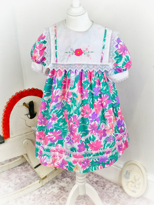 5-6 years. Vibrant floral vintage dress with white bib and flower embroidery